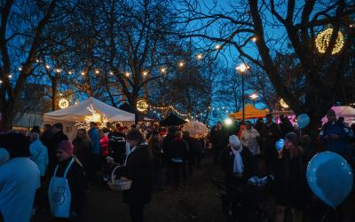 Ihmisiä katsomassa Hehkun ohjelmaa valaistussa Rauhanpuistossa.